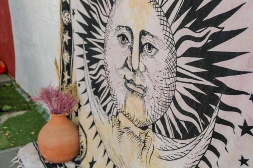a painting of a face on a wall next to a vase at Hotel Kostis in Skiathos Town