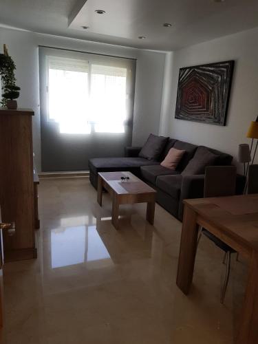 een woonkamer met een bank en een tafel bij HR PARADISE PARQUE RESIDENCIAL in Benidorm