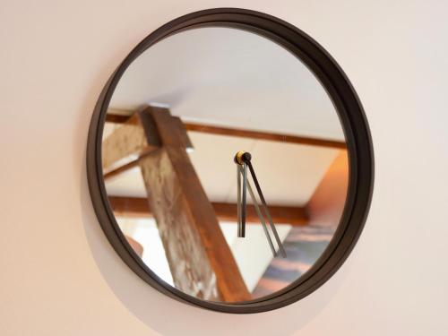 a mirror hanging on a wall with a wooden ladder at Studio Torenzicht in Westkapelle