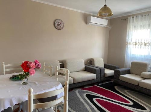 un soggiorno con tavolo e fiori di Dibra's Apartment a Shkodër