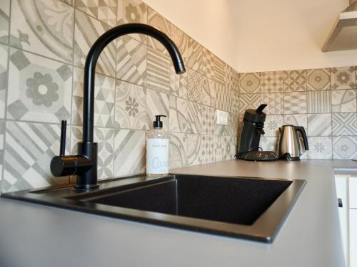 a kitchen sink with a black counter top at Studio Torenzicht in Westkapelle