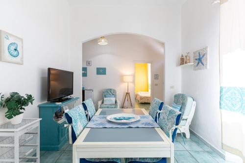 una sala da pranzo con tavolo e sedie bianchi di Confortevole appartamento provenzale a SantʼAntìoco
