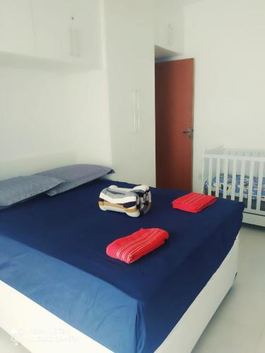 a bed with two red pillows on top of it at Casa-2 Condomínio Elza em Arraial do Cabo in Arraial do Cabo