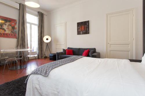 une chambre avec un lit blanc et un canapé dans l'établissement 1 bedroom appartement Cannes (Carnot), à Cannes