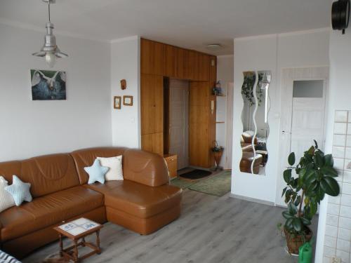 a living room with a brown leather couch at Sopot apartament z widokiem na Morze in Sopot