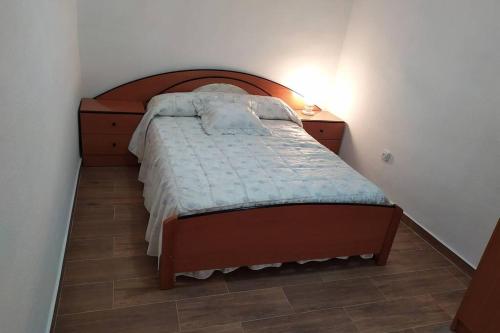 a bedroom with a bed with a wooden headboard at Una llar amb vista a L'Ampolla in L'Ampolla