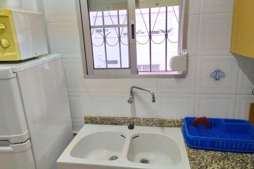 a white sink in a bathroom with a window at Una llar amb vista a L'Ampolla in L'Ampolla