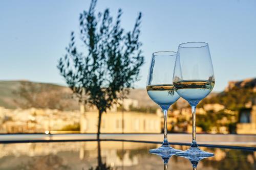 dos vasos de vino blanco sentados en una mesa en MiraMe Athens Boutique Hotel-House of Gastronomy, en Atenas