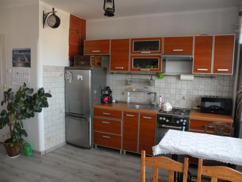 a kitchen with wooden cabinets and a stainless steel refrigerator at Sopot apartament z widokiem na Morze in Sopot