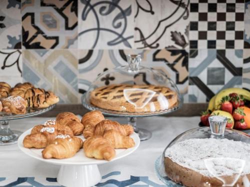 a table topped with plates of pastries and pies at Hotel Lory in Forlì