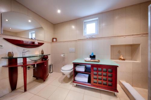 een badkamer met een toilet en een rode wastafel bij B&B Villa Vis in Vis