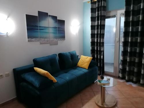 a living room with a blue couch with yellow pillows at Apartments Dario in Pag