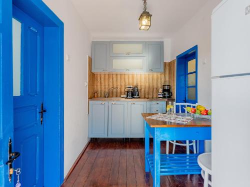 une cuisine avec des placards bleus et une table bleue dans l'établissement Casa de vacanta traditionala romaneasca, à Schiuleşti