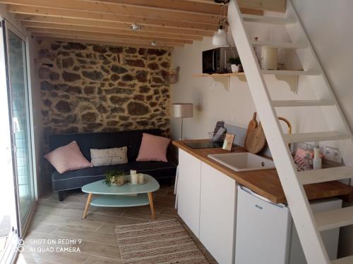 eine Küche und ein Wohnzimmer mit einem Sofa und einem Tisch in der Unterkunft Charmant logement T2 à 2 pas de la mer in Granville