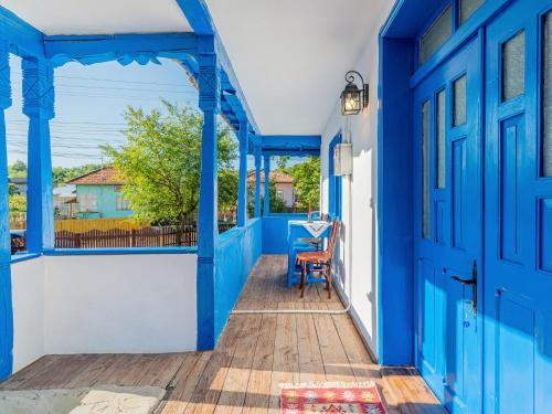 a blue and white house with a blue door at Casa de vacanta traditionala romaneasca in Schiuleşti