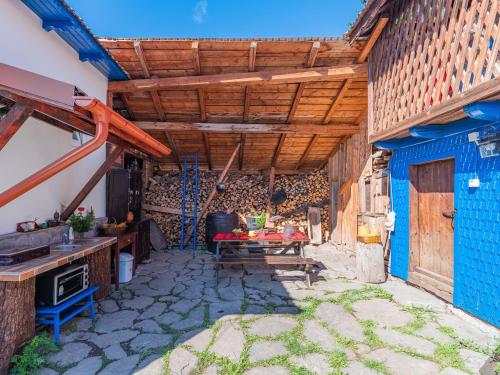 an outdoor kitchen with a table and a stove at Casa de vacanta traditionala romaneasca in Schiuleşti