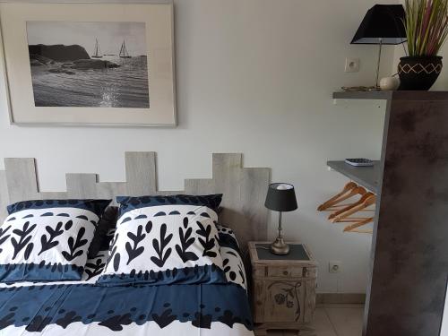 een slaapkamer met een bed met blauwe en witte kussens bij LA GRIOTTE 2 & Spa&Piscine in Pennedepie