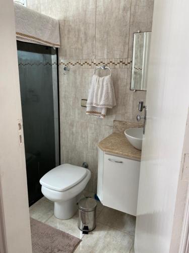 a bathroom with a toilet and a sink and a shower at CASA FAMILIAR “SANTA PAZ” in Aparecida