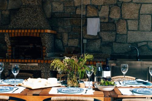 a wooden table with plates and wine glasses on it at Magníficos Dias Atlânticos in Moledo