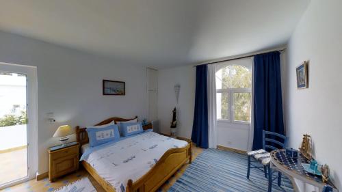 a bedroom with a bed and a large window at Villa Daba in Ghazoua