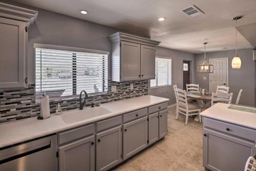 a kitchen with a sink and a dining room at Updated Home with Outdoor Oasis, 2 Mi to Lake! in Lake Havasu City