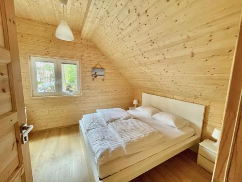 a bedroom with a bed in a wooden room at AJ Apartments in Pobierowo