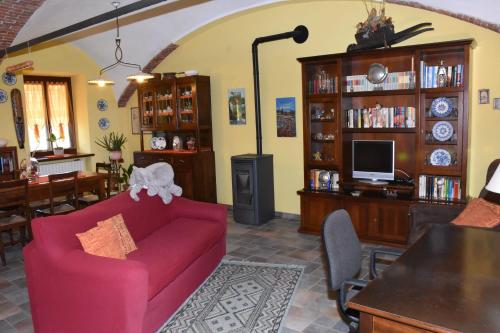ein Wohnzimmer mit einem roten Sofa und einem TV in der Unterkunft La casa di Enzo in Lequio Tanaro