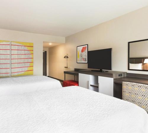 a hotel room with two beds and a desk with a television at Snoqualmie Inn by Hotel America in Snoqualmie