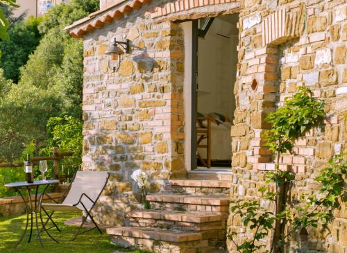 a brick house with a window and a chair at Locanda Le Tre Sorelle in Casal Velino