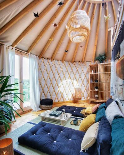 a living room with a blue couch in a yurt at LushHills - Stylowa i Naturalna Jurta in Regulice