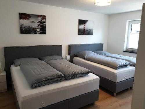 two beds in a bedroom with two bedsskirts at Panorama Apartments in Füssen