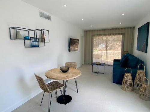 a living room with a table and a blue couch at Résidence Storia d'Estate in LʼÎle-Rousse