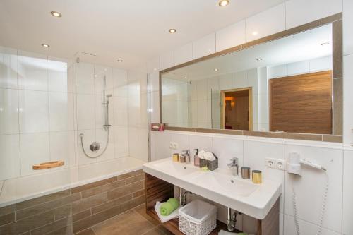 a bathroom with a sink and a tub and a mirror at Ferienwohnung "Mein Alpenjuwel" in Filzmoos