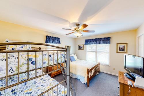 a bedroom with two bunk beds and a ceiling fan at Serenity at the Lake in Lake Murray Shores