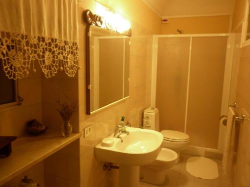 a bathroom with a sink and a toilet and a mirror at La Terrazza sul Monferrato in Ozzano Monferrato