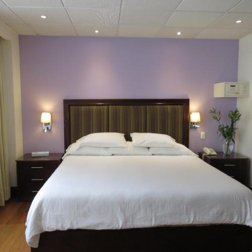 a bedroom with a large white bed with purple walls at Suites Melchor Ocampo 445 in Mexico City