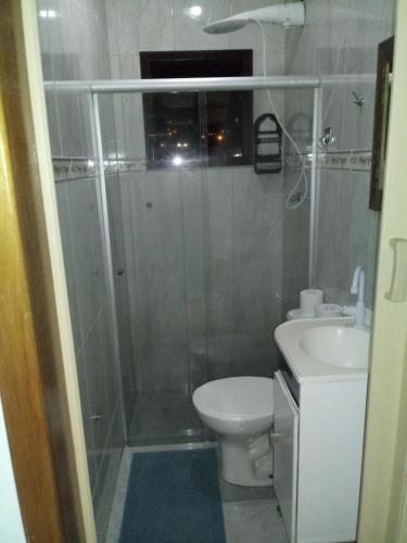 een badkamer met een douche, een toilet en een wastafel bij Casa Eudileia in Campos do Jordão