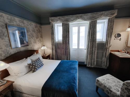 a hotel room with a bed and a window at Le Chateau de Pierre in Quebec City
