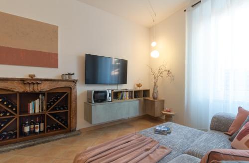 a living room with a flat screen tv on a wall at Casa del Borgo "Terra & Fuoco" sul Lago Maggiore in Maccagno Inferiore