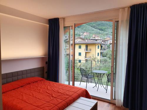 a bedroom with a red bed and a large window at Hotel Internazionale in Malcesine