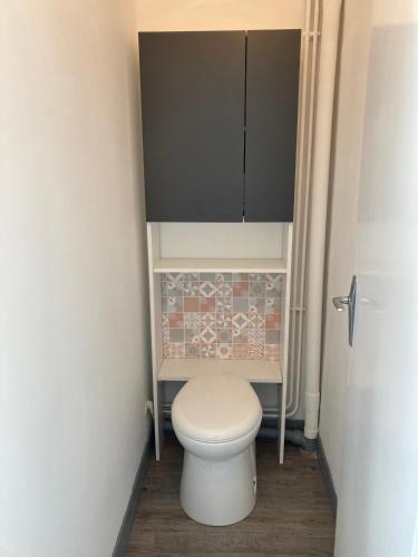 a small bathroom with a toilet and a cabinet at F2 Vire centre in Vire