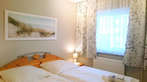 a bedroom with a bed and a window at Südwäldchen in Westerland (Sylt)