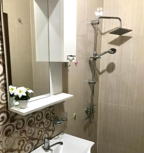 łazienka z umywalką, lustrem i prysznicem w obiekcie David APT 1A w mieście Batumi