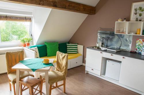 uma pequena cozinha com mesa e cadeiras num quarto em Dom przy borowinie em Kolobrzeg