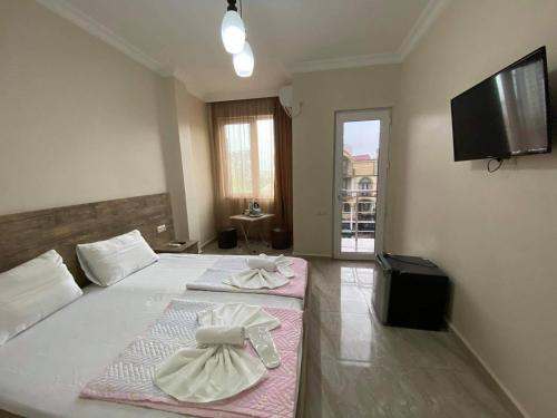 a bedroom with two beds and a flat screen tv at Family Hotel in Batumi