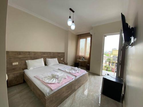 a bedroom with a large bed and a large window at Family Hotel in Batumi