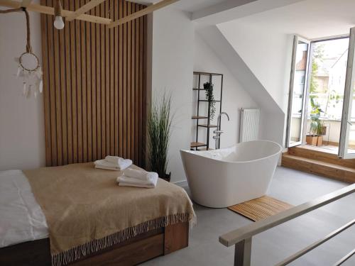 ein Bad mit einer Badewanne und einem Bett in der Unterkunft B&N Apartments in Mrągowo