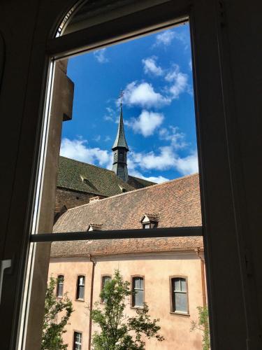 a window view of a building with a tower at Bonjour Colmar in Colmar