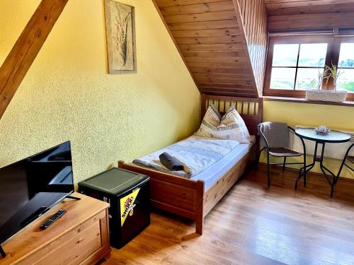 a small bedroom with a bed and a table at EDER- Penzion & Apartmány in Horní Planá