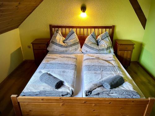 a wooden bed with pillows and blankets on it at EDER- Penzion & Apartmány in Horní Planá